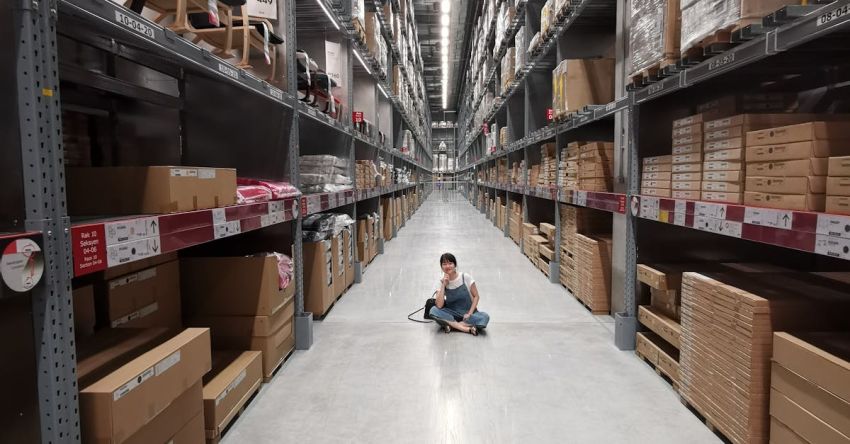 Inventory - Person Sitting on Ground Between Brown Cardboard Boxes