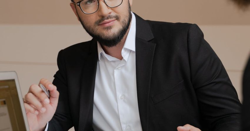 Negotiations - A Bearded Man in Black Suit Wearing Eyeglasses